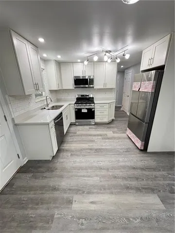 a large kitchen with a stove a sink dishwasher and a refrigerator