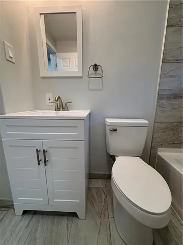 a white toilet sitting next to a bathroom sink