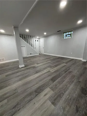 an empty room with wooden floor and stairs