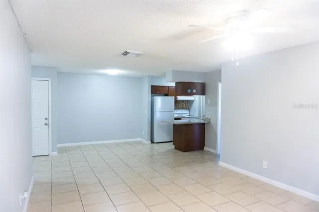 a view of kitchen with refrigerator and window