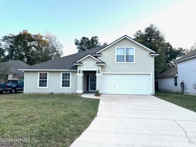 a view of a house with a yard and garage