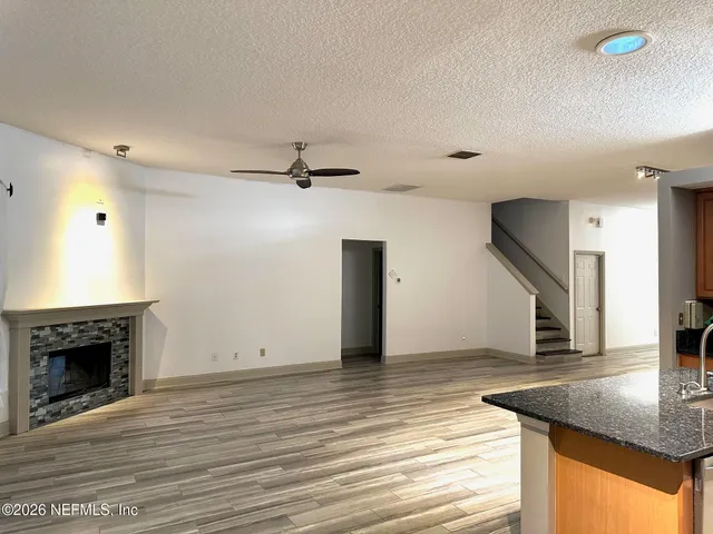 a view of a livingroom with wooden floor and a ceiling fan