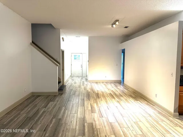 a view of empty room with wooden floor