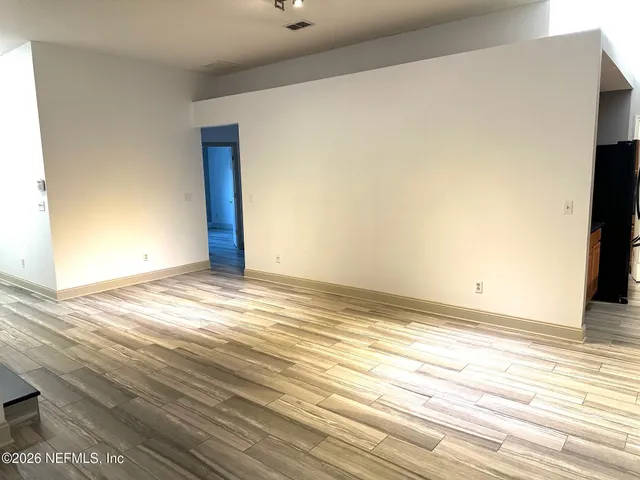 a view of empty room with wooden floor