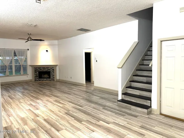 a view of a livingroom with wooden floor and staircase