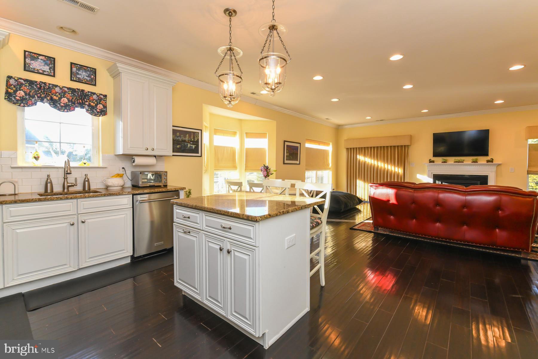 111 Weatherby Lane Glassboro, NJ 08028 - Photo 24 of 95 a open kitchen with stainless steel appliances granite countertop a sink dishwasher a stove and a dining table with wooden floor