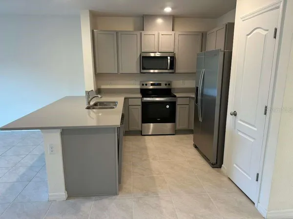 a kitchen with stainless steel appliances a refrigerator stove and microwave