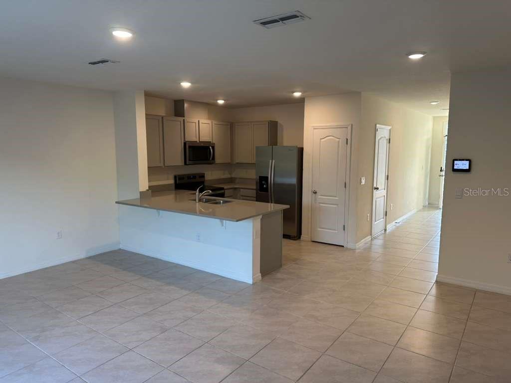 1773 Rock Elm Road Davenport, FL 33837 - Photo 11 of 23 a kitchen with stainless steel appliances a refrigerator and a stove top oven