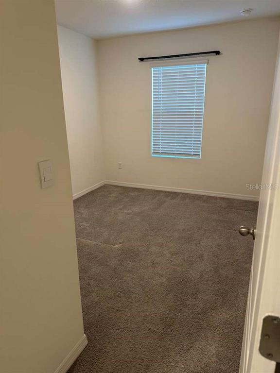 1773 Rock Elm Road Davenport, FL 33837 - Photo 16 of 23 an empty room with a wooden door and a window