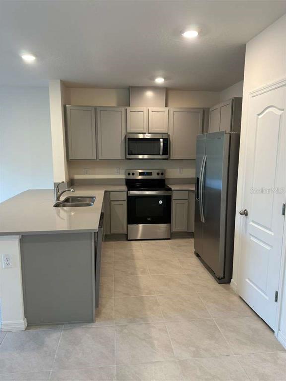 1773 Rock Elm Road Davenport, FL 33837 - Photo 23 of 23 a kitchen with stainless steel appliances granite countertop a refrigerator sink and stove