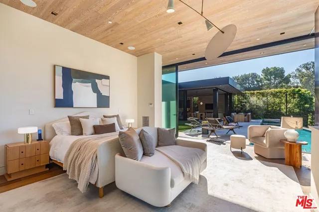 a bedroom with furniture and a large window