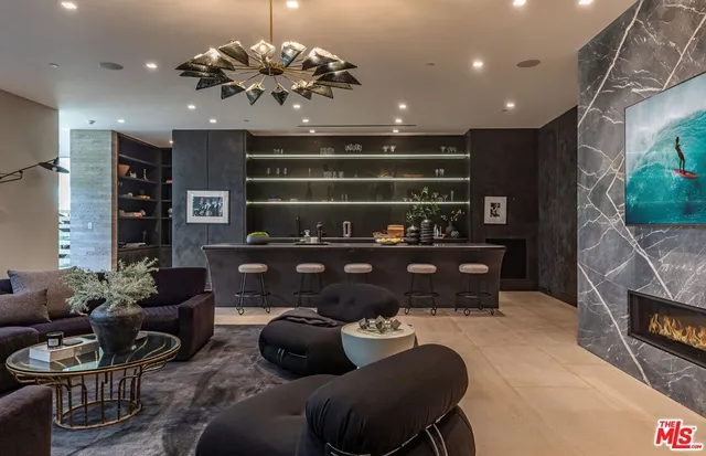 a living room with furniture a fireplace and a chandelier