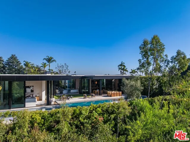 a view of house with swimming pool and furniture