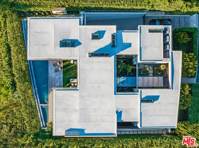 aerial view of a house with a yard and potted plants