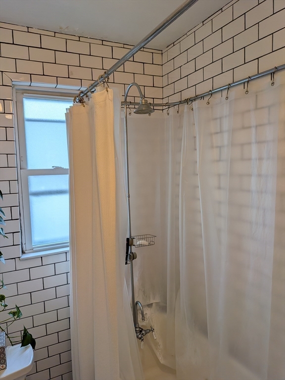 82 Gladstone Street, Unit 2 Boston, MA 02128 - Photo 12 of 23 a bathroom with a shower and a tub