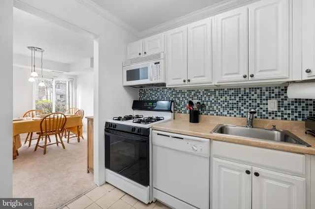 a kitchen with white cabinets and white appliances