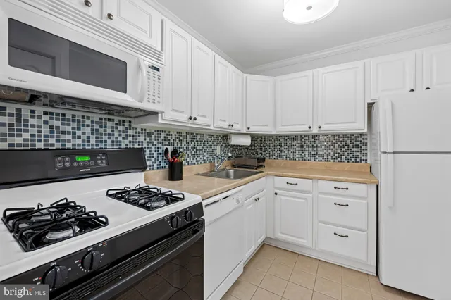 a kitchen with white cabinets and appliances