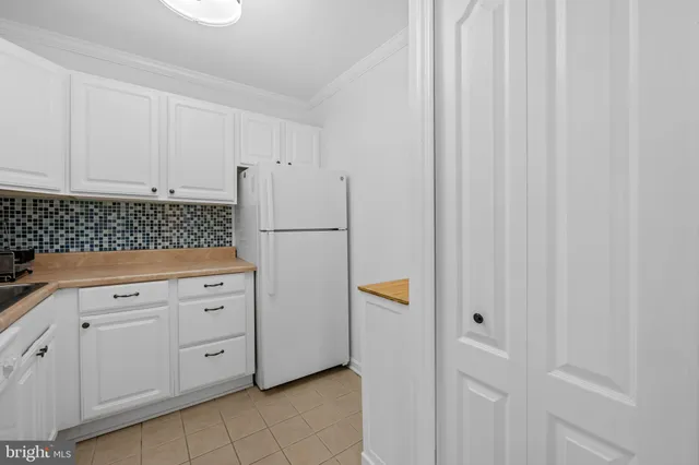 a kitchen with white cabinets and white appliances
