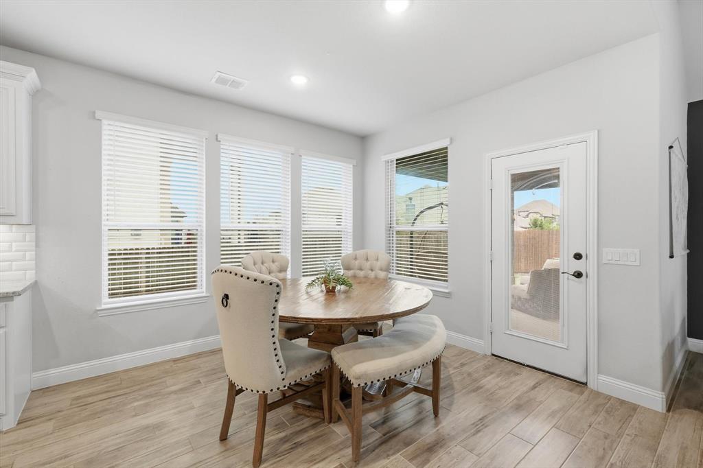 924 Timber Ridge Drive Justin, TX 76247 - Photo 14 of 32 Bright dining area featuring wood-finish flooring, multiple windows with blinds, recessed lighting, and a glass-paneled exterior door