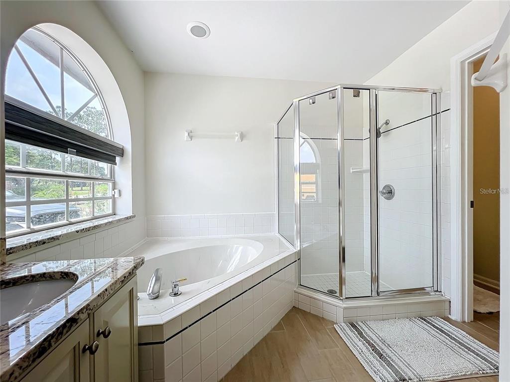 17528 East Apshawa Road Minneola, FL 34715 - Photo 11 of 22 a bathroom with a tub a mirror and a shower