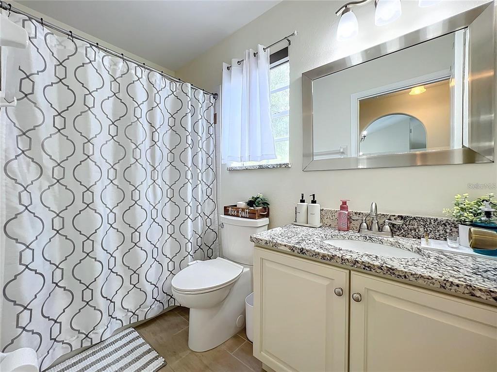 17528 East Apshawa Road Minneola, FL 34715 - Photo 13 of 22 a bathroom with a granite countertop sink and a toilet