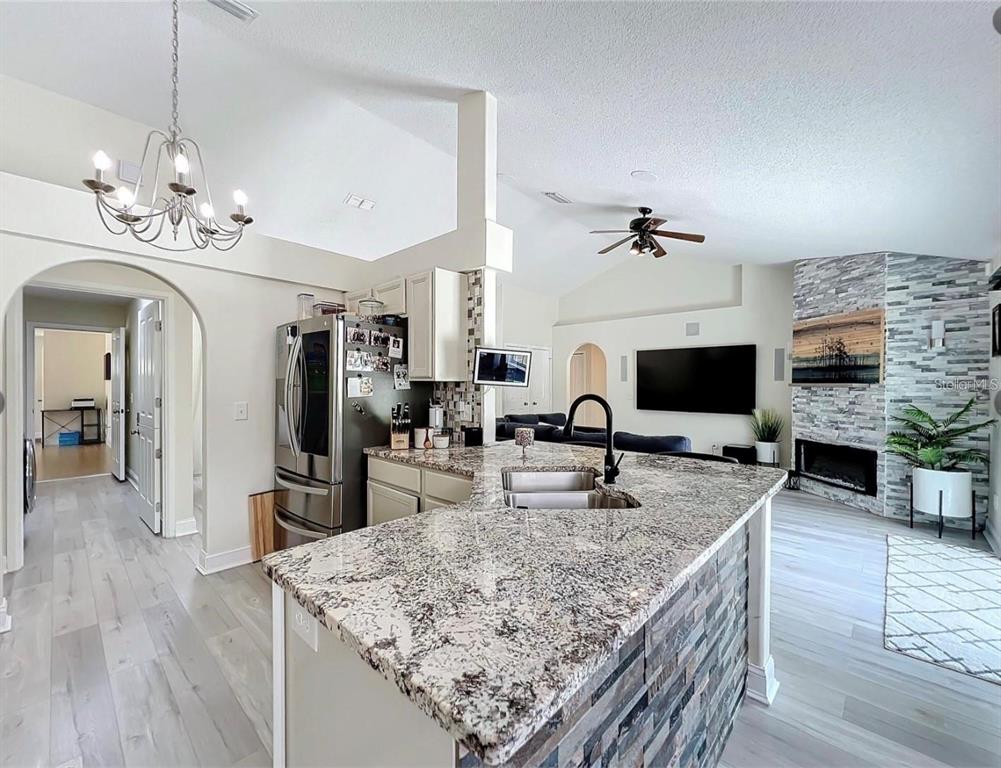 17528 East Apshawa Road Minneola, FL 34715 - Photo 2 of 22 a view of living room kitchen with granite countertop couches and fireplace