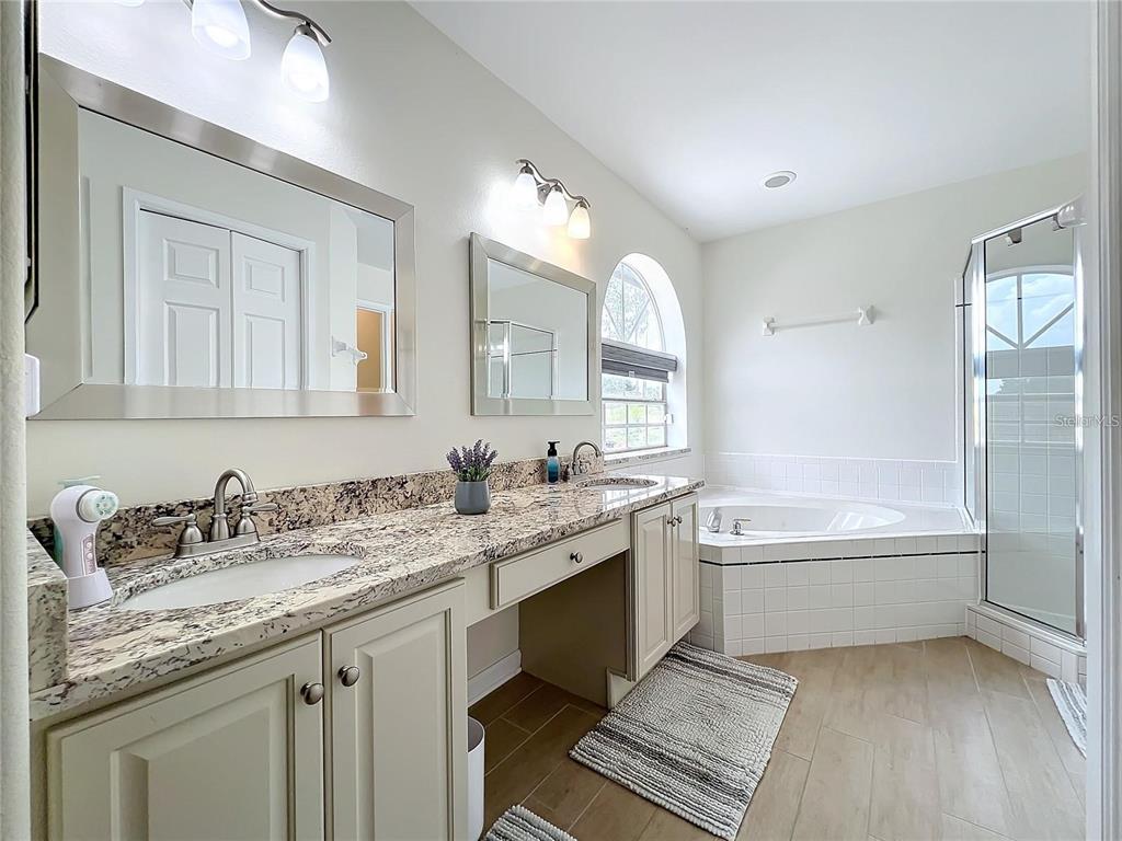 17528 East Apshawa Road Minneola, FL 34715 - Photo 10 of 22 a bathroom with a granite countertop bathtub a double vanity sink and a