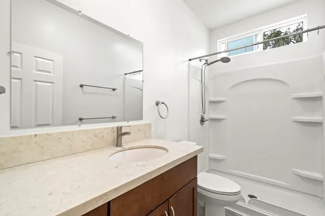 an aerial view of residential houses with outdoor space and trees