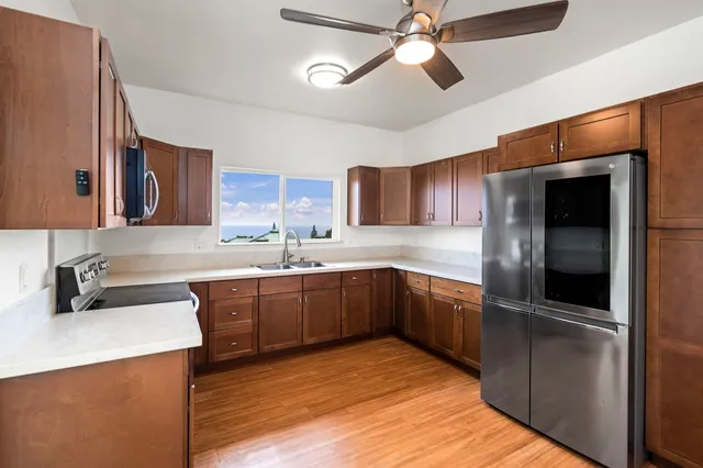 a kitchen with stainless steel appliances kitchen island granite countertop a refrigerator a sink dishwasher a stove and a microwave oven with cabinets