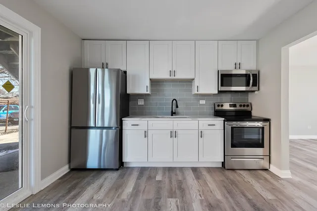 a kitchen with a refrigerator stove and white cabinets