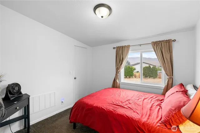 a bed sitting in a bedroom next to a window