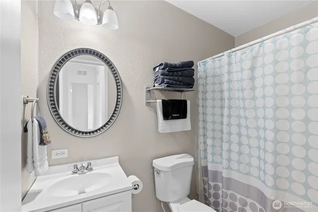 a bathroom with a toilet a sink and a mirror