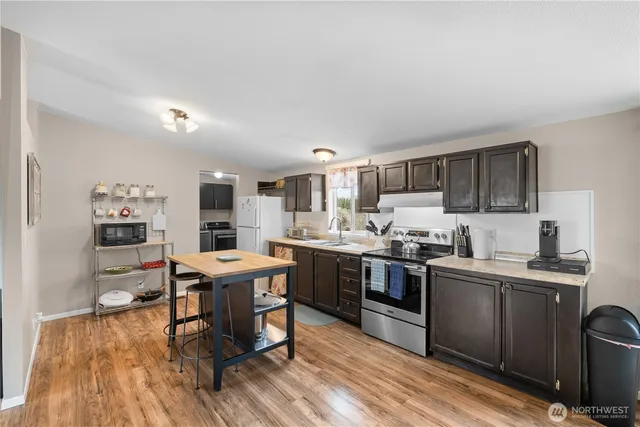 a kitchen with stainless steel appliances kitchen island granite countertop a sink and cabinets