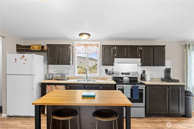 a kitchen with kitchen island a stove a table and chairs
