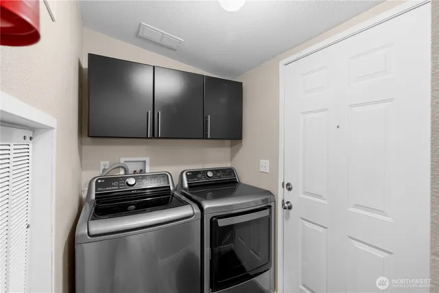 a view of a storage and utility room with washer and dryer
