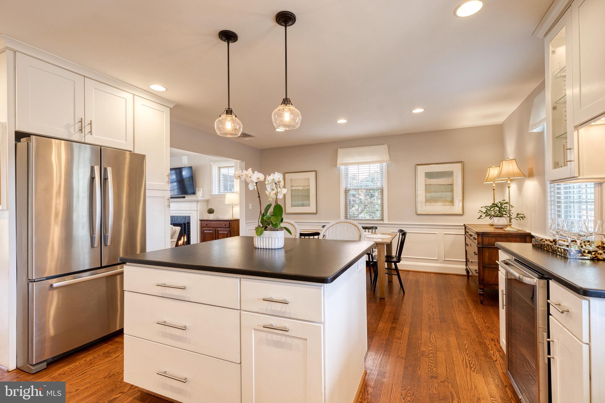 45 Dunkirk Road Baltimore, MD 21212 - Photo 26 of 45 a kitchen with stainless steel appliances granite countertop a refrigerator a stove a sink dishwasher and a dining table with wooden floor