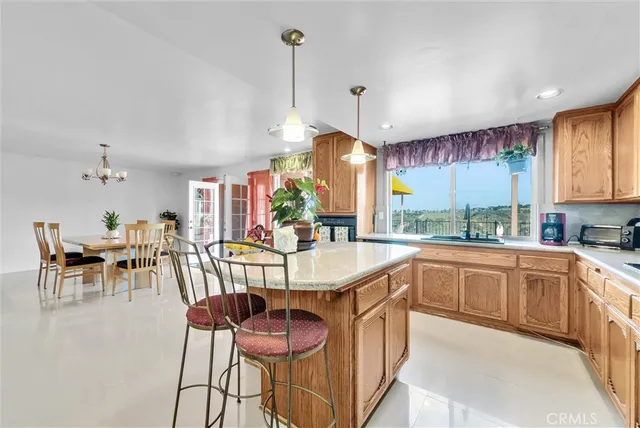 a living room with furniture kitchen view and a chandelier