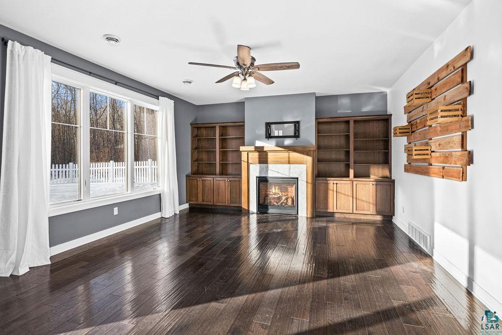 3879 Okerstrom Road Hermantown, MN 55811 - Photo 13 of 32 Unfurnished living room with a ceiling fan, dark wood finished floors, and a high end fireplace