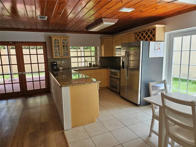 a kitchen with refrigerator and wooden cabinets