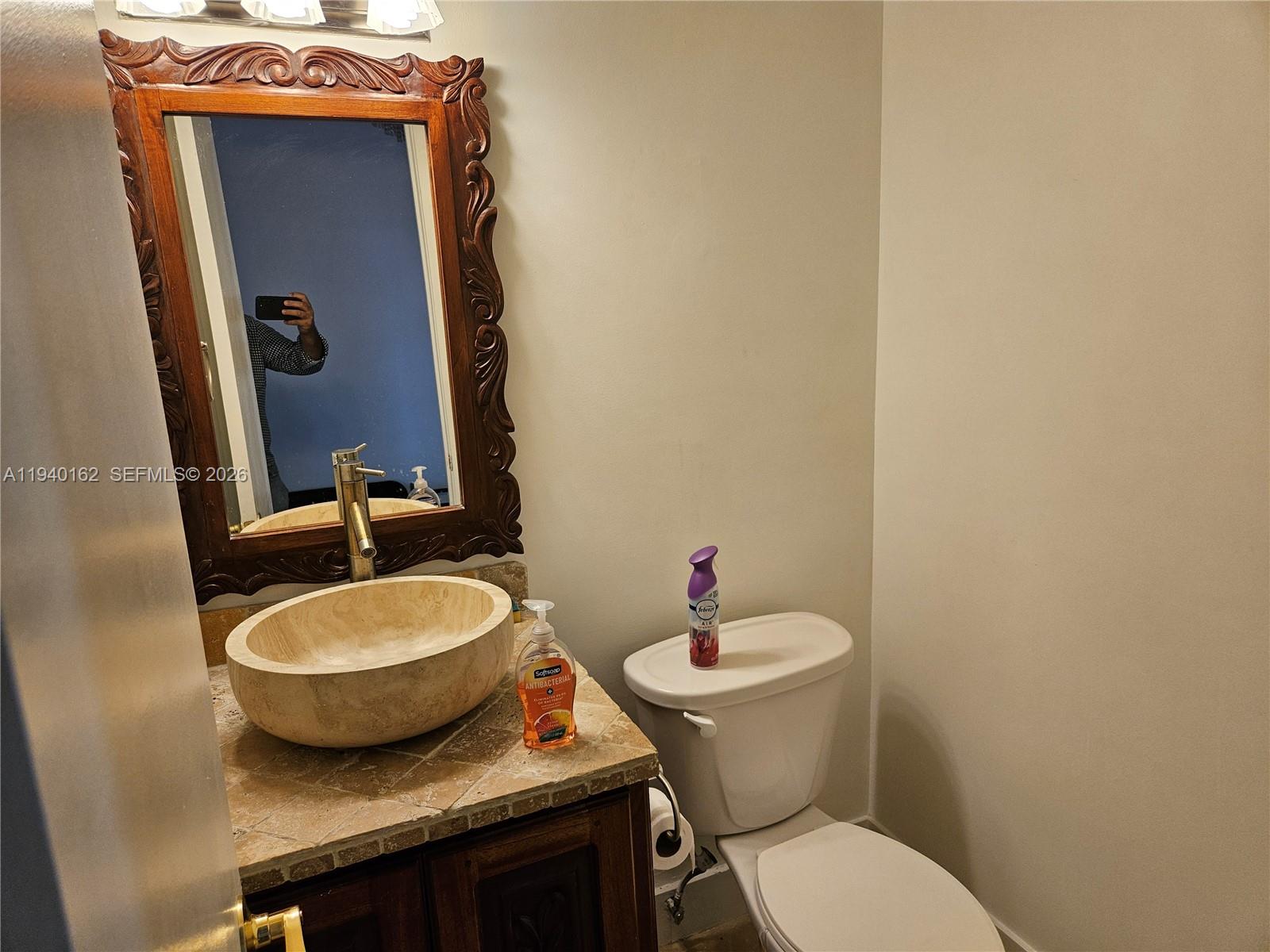 9154 Southwest 132nd Lane, Unit 1 Miami, FL 33176 - Photo 5 of 14 a bathroom with a granite countertop toilet a sink and mirror