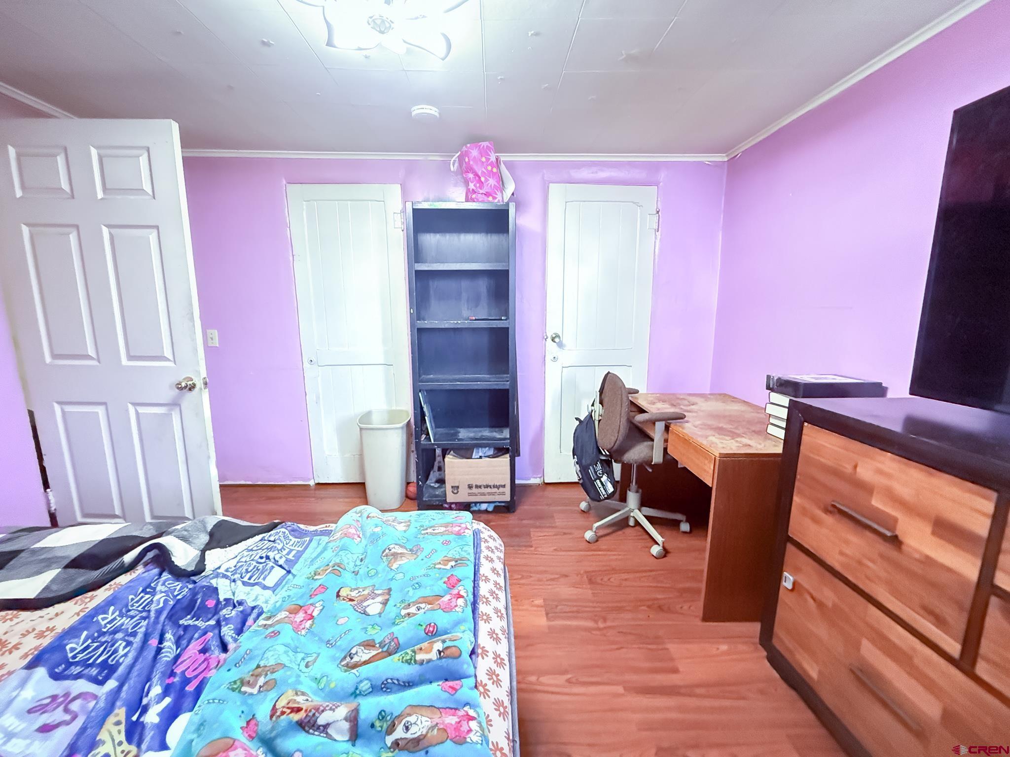 432 North Linden Street Cortez, CO 81321 - Photo 12 of 27 a bedroom with a bed and wooden floor