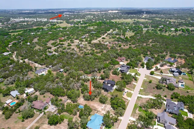 an aerial view of a houses with a lush green hillside
