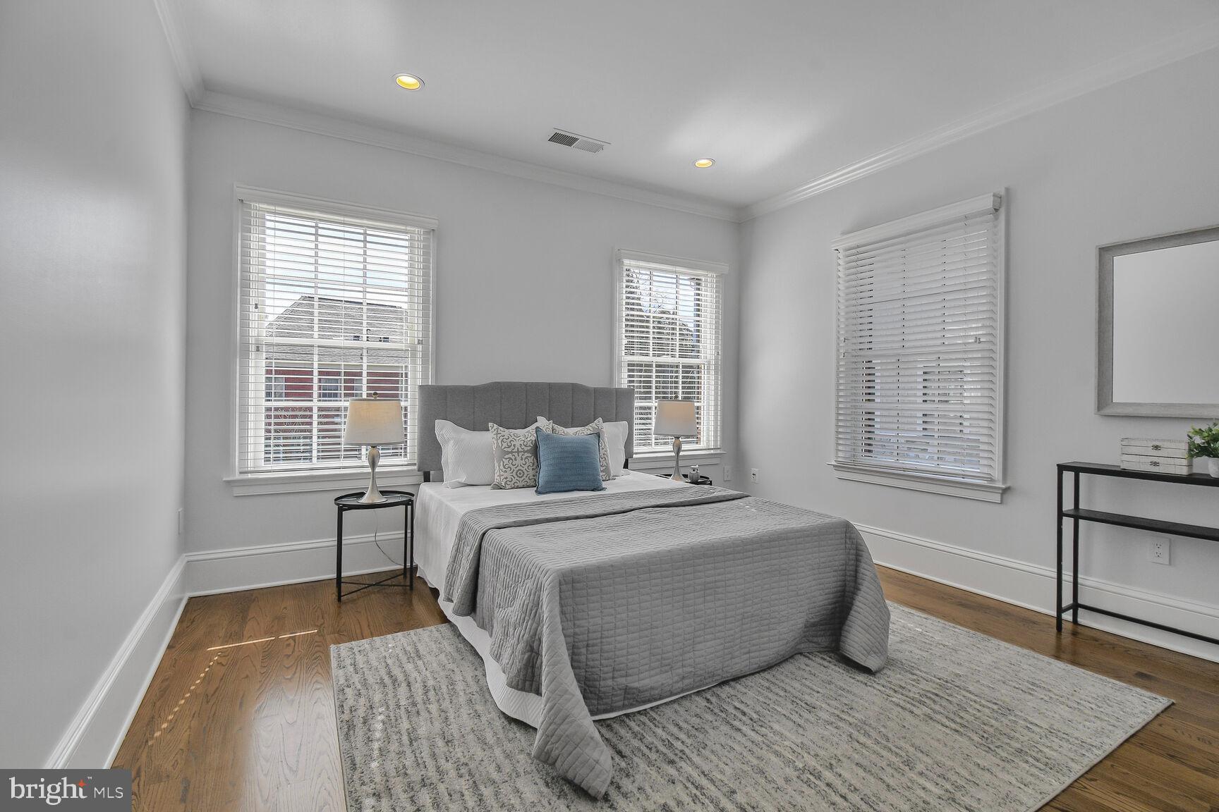 1935 Foxview Circle Northwest Washington, DC 20007 - Photo 32 of 52 a bedroom with a large bed wooden floor and windows