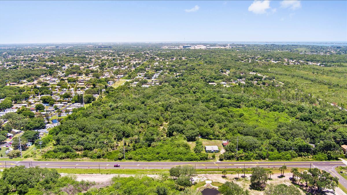 880 Malabar Road Malabar, FL 32950 - Photo 7 of 7 an aerial view of a city with lots of residential buildings and mountain view in back