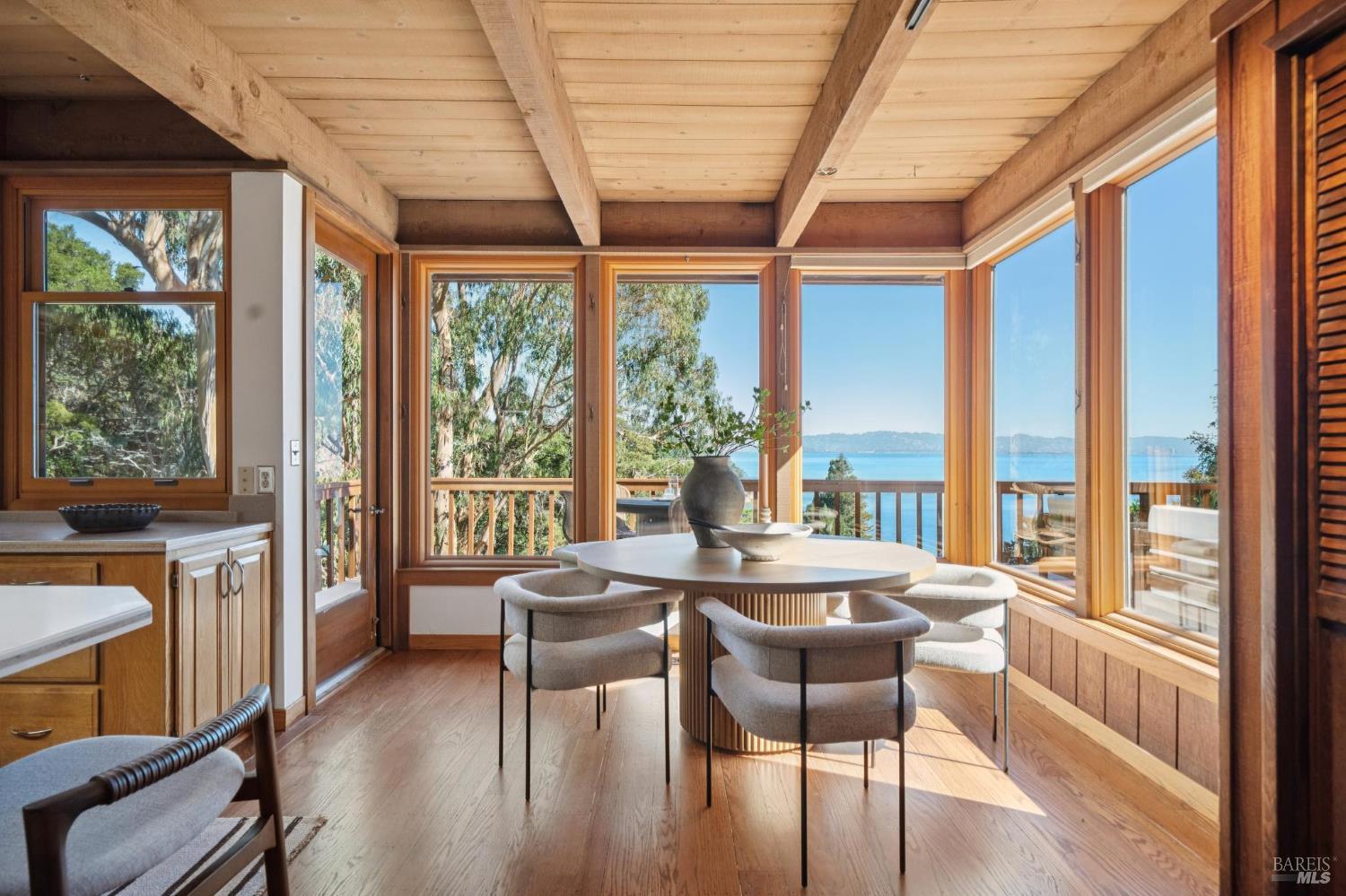 2490 Spanish Trail Road Tiburon, CA 94920 - Photo 13 of 32 a dining room with furniture large windows and wooden floor