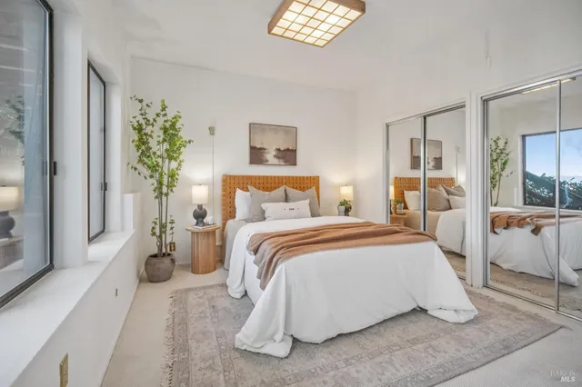 a bedroom with a large bed and a chandelier