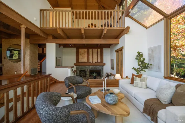 a living room with furniture a fireplace and a large window