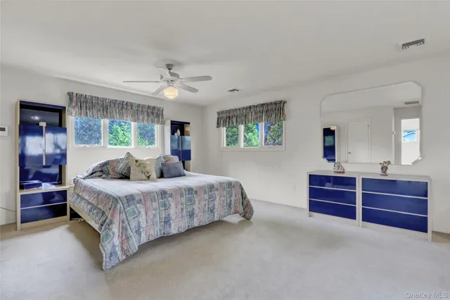 a spacious bedroom with a bed and a dresser