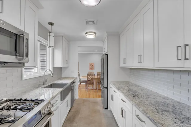 a large kitchen with granite countertop a stove and a sink