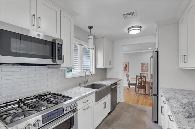 a kitchen with stainless steel appliances a sink a stove and cabinets
